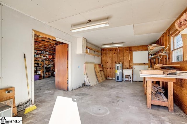 garage with electric water heater, a sink, and a workshop area