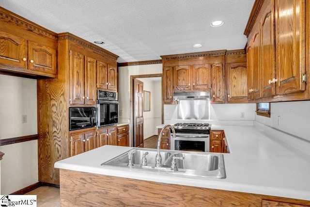 kitchen with stainless steel range with gas cooktop, brown cabinets, light countertops, black oven, and under cabinet range hood