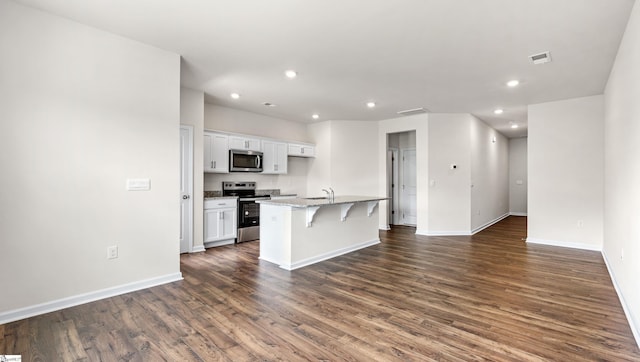 106 Sunriff Ct, Greer, SC 29651 - kitchen with appliances with stainless steel finishes, open floor plan, white cabinets, dark wood finished floors, and recessed lighting