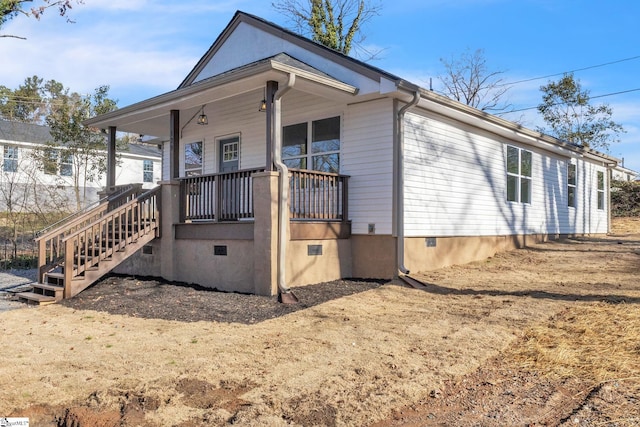 view of front of home featuring a porch, crawl space, and stairway