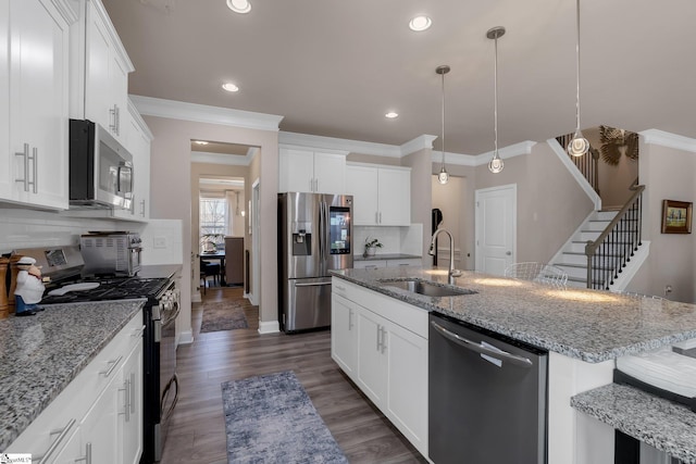 kitchen with appliances with stainless steel finishes, white cabinetry, and a sink