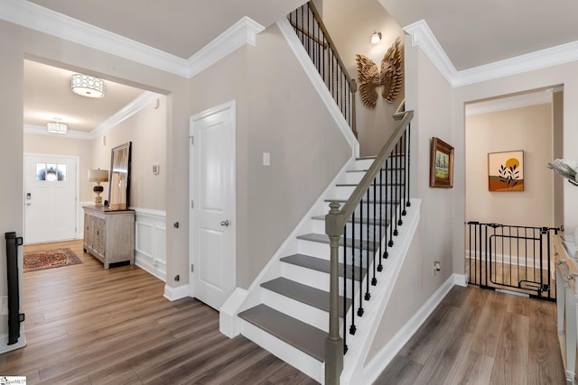 stairway featuring crown molding, baseboards, and wood finished floors