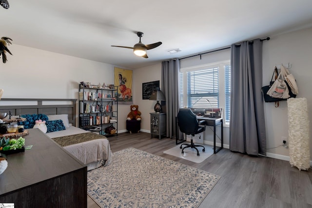 bedroom with baseboards, visible vents, ceiling fan, and wood finished floors