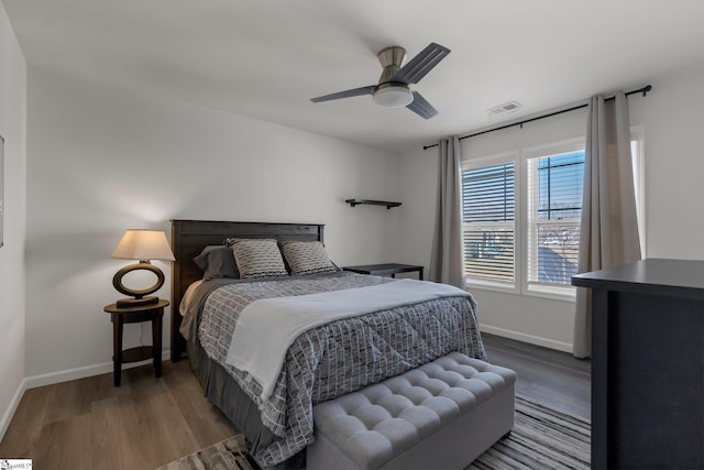 bedroom with ceiling fan, dark wood finished floors, visible vents, and baseboards