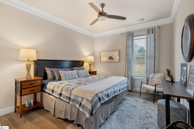 bedroom featuring ornamental molding, baseboards, visible vents, and light wood finished floors