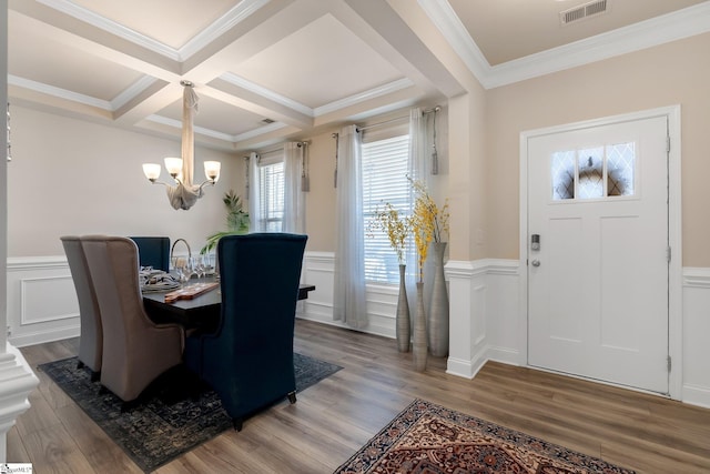 dining room with crown molding, visible vents, an inviting chandelier, wood finished floors, and coffered ceiling