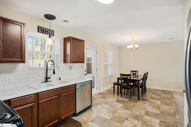 kitchen with visible vents, decorative backsplash, decorative light fixtures, stainless steel dishwasher, and a sink