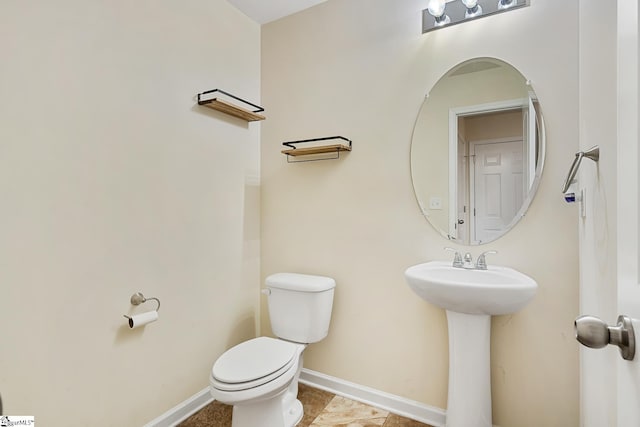 bathroom with toilet and baseboards