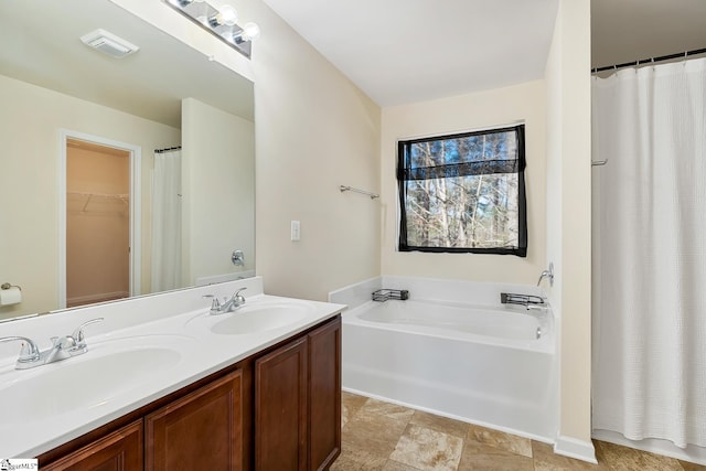 bathroom featuring visible vents, double vanity, a sink, and a bath