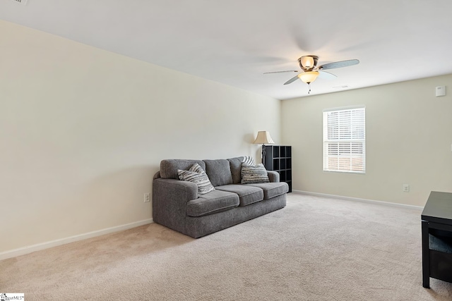 living area featuring ceiling fan, baseboards, and light colored carpet