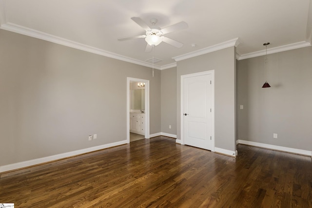 unfurnished bedroom with dark wood-style flooring, ensuite bathroom, attic access, ornamental molding, and baseboards