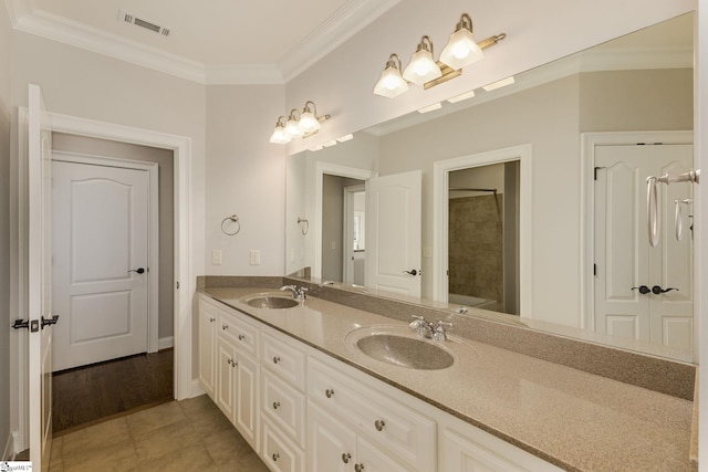 full bathroom with double vanity, a sink, visible vents, and crown molding