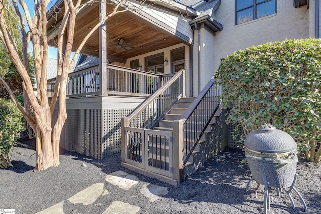 property entrance featuring ceiling fan, brick siding, and a shingled roof