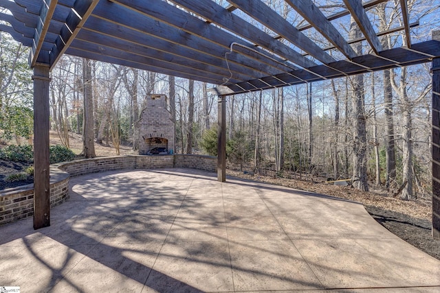 view of patio with an outdoor brick fireplace and a pergola