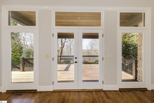 doorway with dark wood-style floors, visible vents, and a healthy amount of sunlight