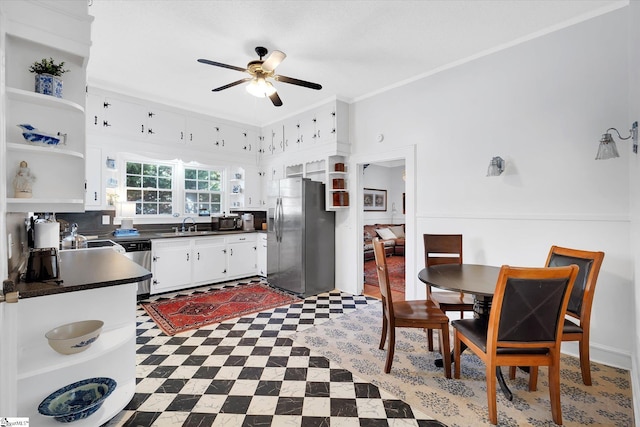 kitchen featuring white cabinets, dark countertops, stainless steel appliances, crown molding, and open shelves