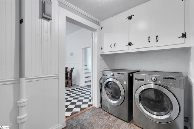 laundry room with light floors, cabinet space, and washing machine and clothes dryer