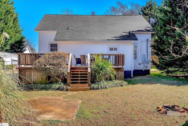 rear view of property with a deck, stairway, and a lawn