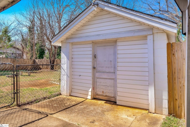 view of outbuilding featuring a gate, fence, and an outdoor structure