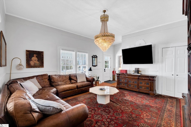 living area featuring crown molding, wood finished floors, and an inviting chandelier