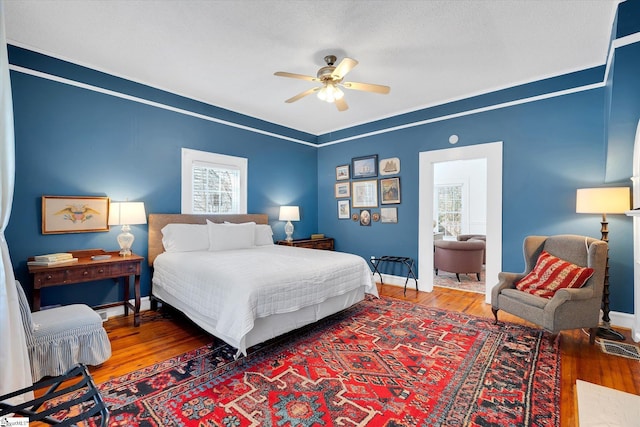 bedroom featuring wood finished floors, a ceiling fan, and baseboards