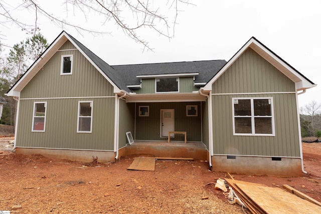 back of house with covered porch, roof with shingles, and crawl space