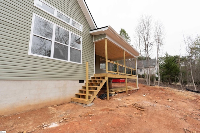 view of side of property with stairway and crawl space