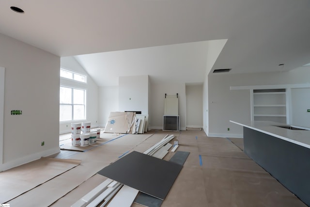 unfurnished living room with vaulted ceiling, built in features, visible vents, and baseboards