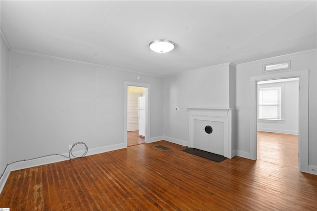 unfurnished living room featuring hardwood / wood-style flooring, visible vents, baseboards, and crown molding