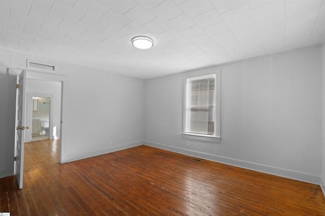 unfurnished bedroom featuring dark wood-type flooring, visible vents, and baseboards