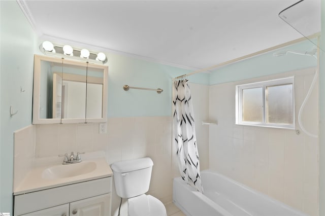 bathroom with toilet, a wainscoted wall, shower / bath combo with shower curtain, vanity, and tile walls