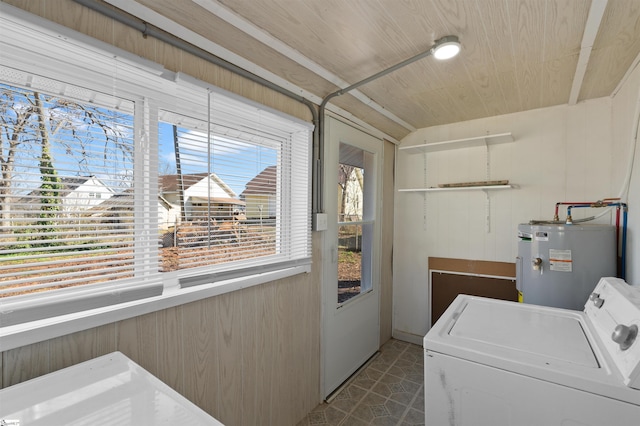 clothes washing area with washer / dryer, laundry area, wooden walls, wooden ceiling, and water heater