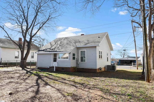 rear view of property with entry steps, central air condition unit, fence, roof with shingles, and crawl space