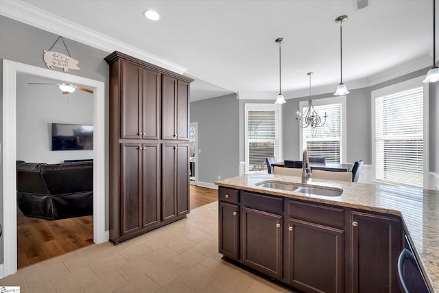 kitchen with ornamental molding, dark brown cabinets, hanging light fixtures, and a sink