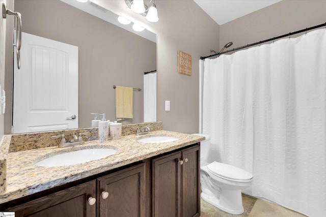 bathroom featuring double vanity, visible vents, toilet, and a sink