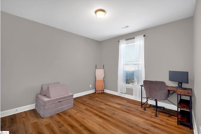 office space featuring visible vents, baseboards, and wood finished floors