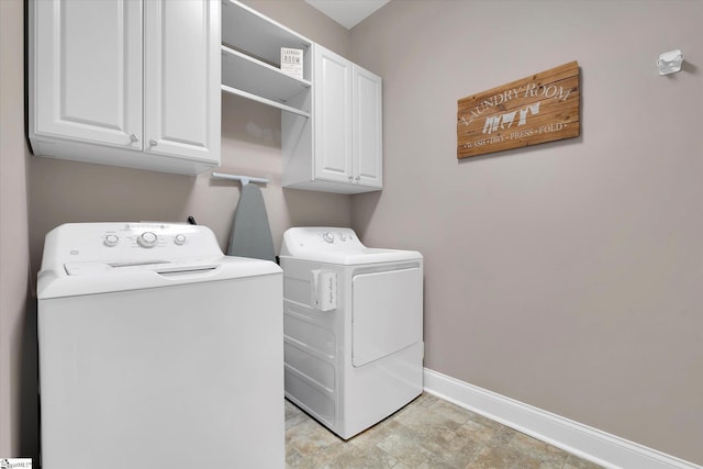 laundry room featuring washer and clothes dryer, cabinet space, and baseboards