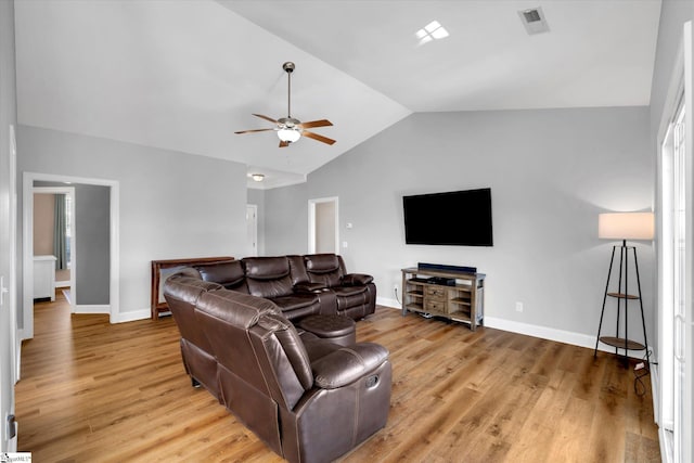 living room featuring light wood-style flooring, visible vents, vaulted ceiling, and baseboards