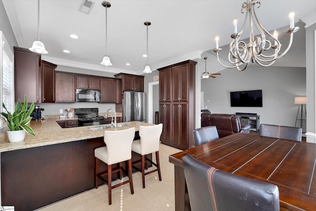 kitchen with decorative light fixtures, visible vents, open floor plan, a sink, and black appliances