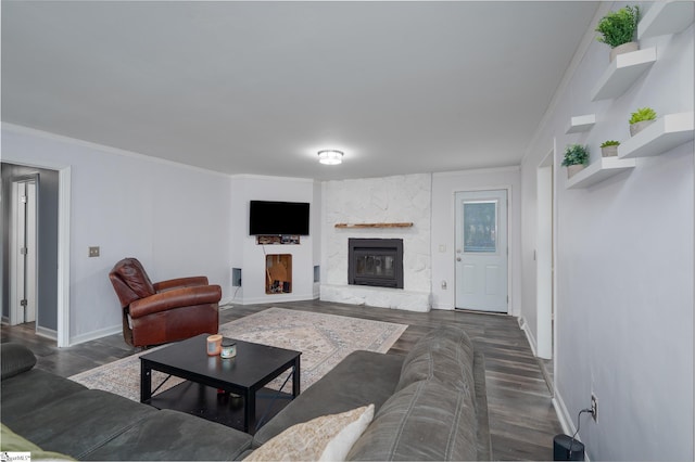 living room with a fireplace, baseboards, dark wood finished floors, and crown molding