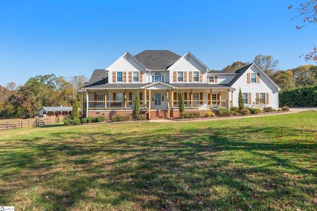 view of front of property featuring a porch, fence, and a front lawn