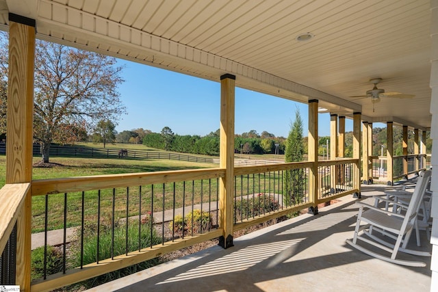 view of patio featuring a rural view, fence, and a ceiling fan