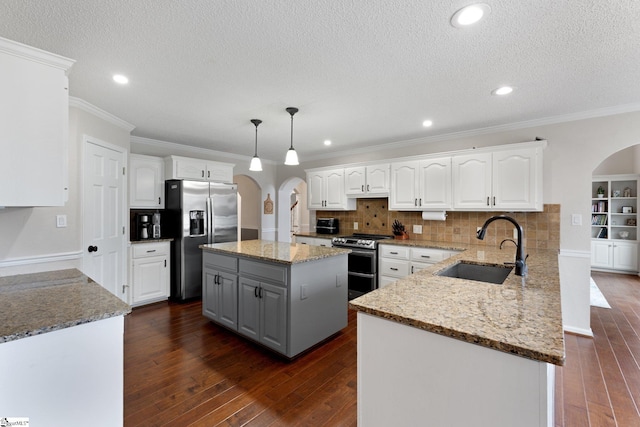 kitchen featuring gray cabinets, appliances with stainless steel finishes, arched walkways, and white cabinets