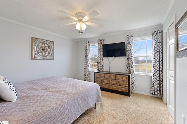 bedroom featuring a textured ceiling, light carpet, a ceiling fan, baseboards, and crown molding