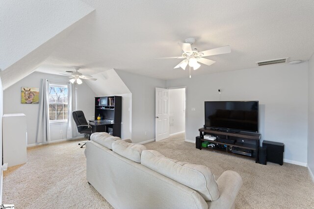 living room with a textured ceiling, visible vents, a ceiling fan, and light colored carpet