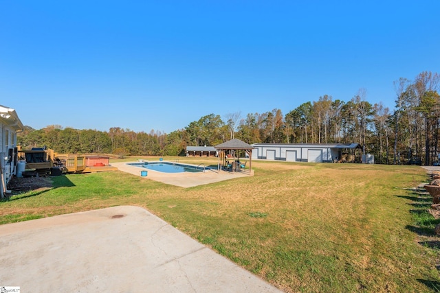 view of yard featuring a gazebo, a patio area, a garage, an outdoor pool, and a wooden deck