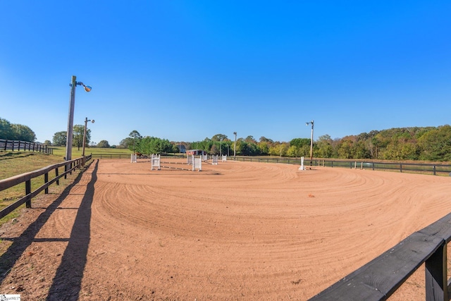 view of home's community with a rural view, an enclosed area, and fence