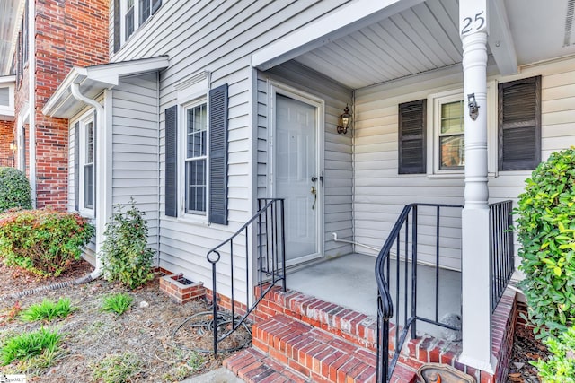 doorway to property featuring a porch and visible vents