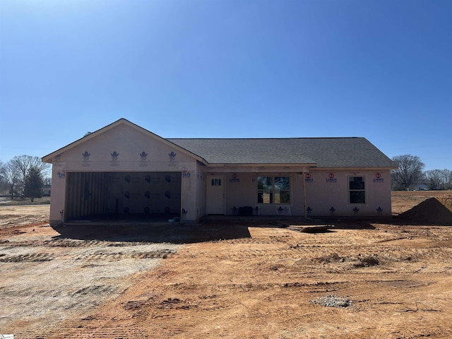 property under construction featuring a garage, driveway, and a shingled roof