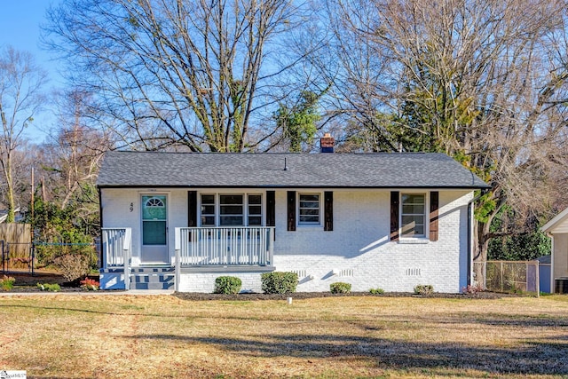 ranch-style home featuring covered porch, brick siding, crawl space, and a front lawn